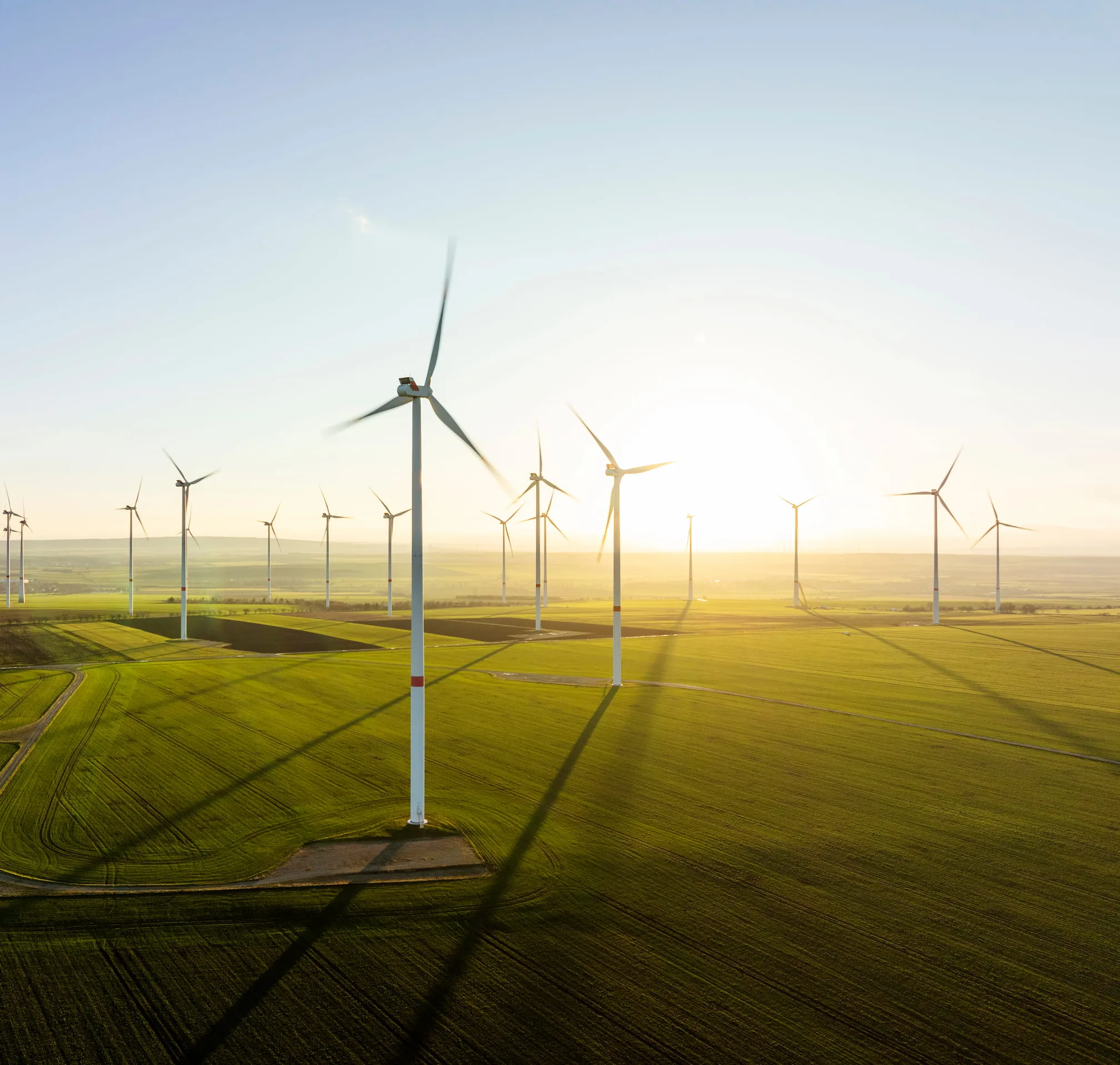 Aerial view of wind turbines backlit by evening light